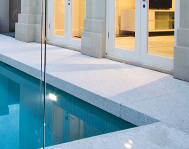 white granite pool coping tiles around a pool